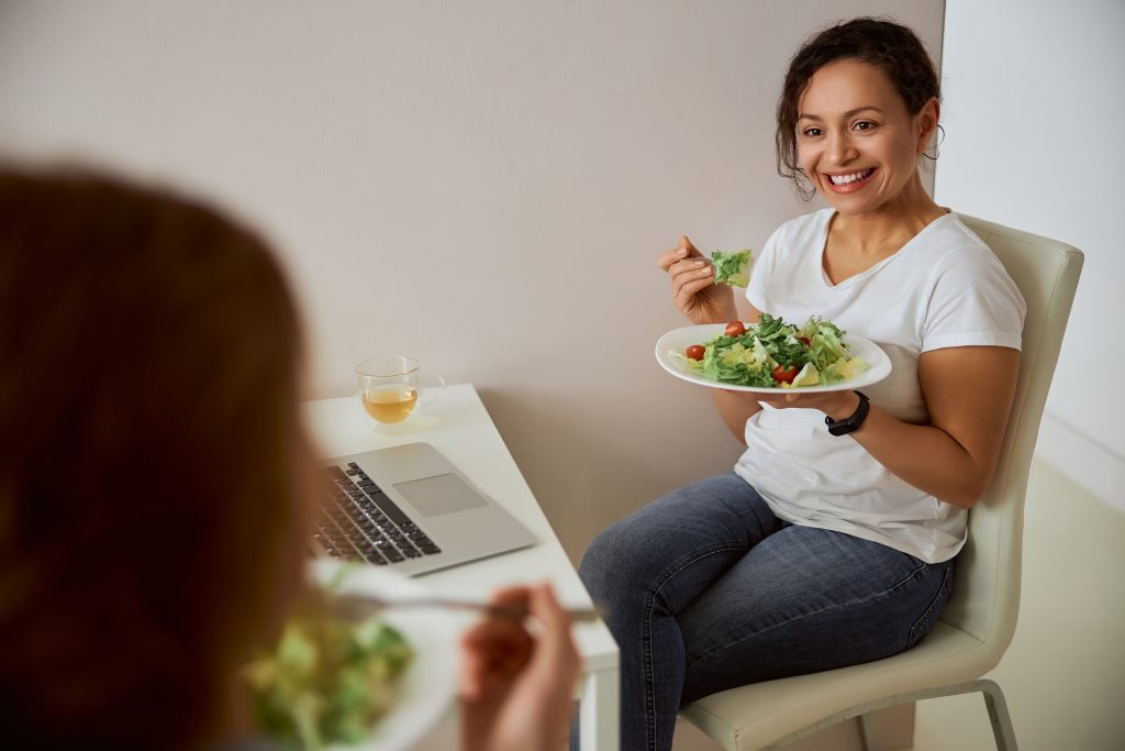 妇女吃绿叶蔬菜，这是叶酸和维生素B9的良好来源